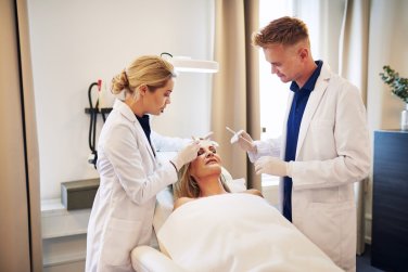 profesionales médicos preparan relleno dérmico en paciente.