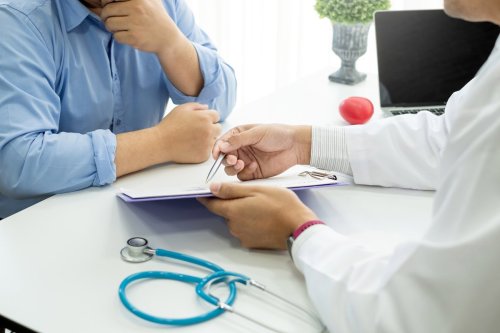 bác sĩ và bệnh nhân xem xét một tờ giấy.