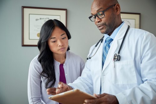 doctor y paciente revisan resultados médicos.