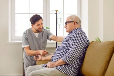 nhân viên hỗ trợ người đàn ông nhận truyền dịch.