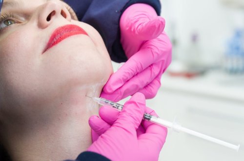 nhân viên tiêm axit deoxycholic vào cằm bệnh nhân.