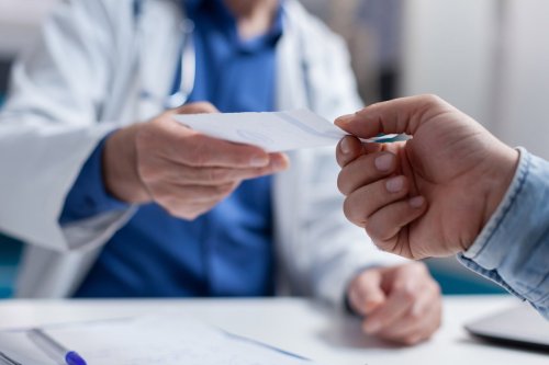 bệnh nhân đưa cho bác sĩ một tờ giấy.