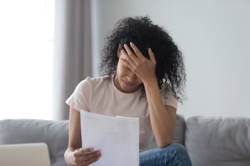 mujer molesta leyendo una hoja de papel.