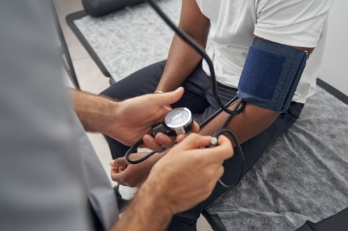 doctor measures blood pressure of patient.