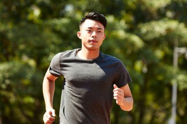 男性在公園跑步健身。