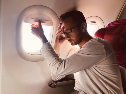 airline passenger by window looks sick or tired.